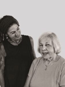 a woman in a black tank top stands next to an older woman