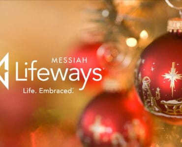 a messiah lifeways logo with a christmas ornament in the foreground