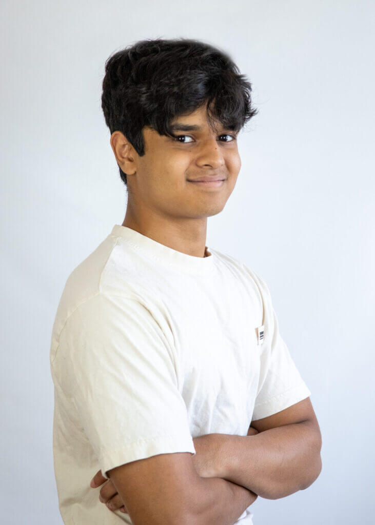 a young man with his arms crossed wearing a white shirt