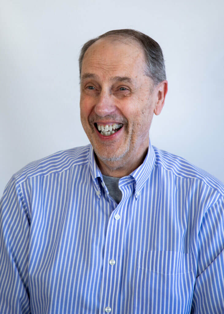 a man wearing a blue and white striped shirt is smiling